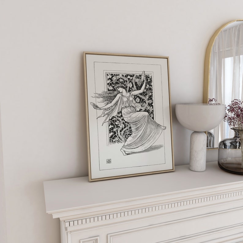 May include: A black and white framed print of a woman dancing in a flowing dress. The woman is surrounded by a floral design. The print is on a white shelf with a white mantle.