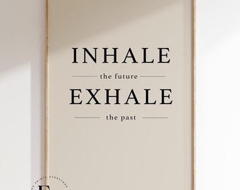 Könnte beinhalten: Ein beiger Poster mit schwarzem Text, der "INHALE the future EXHALE the past" lautet. Der Poster ist in einem hellen Holzrahmen gerahmt.