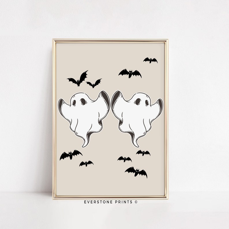 May include: A printable digital download featuring two white ghosts with black eyes and a beige background.  The ghosts are facing each other with their arms raised.  There are several black bats scattered around the ghosts.  The text "EVERSTONE PRINTS &copy;" is at the bottom of the image.