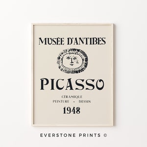 May include: A beige poster with black text that reads "Mus&eacute;e d'Antibes Picasso C&eacute;ramigue Peinture - Dessin 1948" and a black and white illustration of a sun with a face.