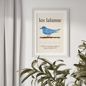 May include: A vintage poster with a blue bird illustration and the text "les lalanne" in black. The poster also includes the text "CNAC 11, rue Berryer Paris 8 5 juin-13 juillet 1975".