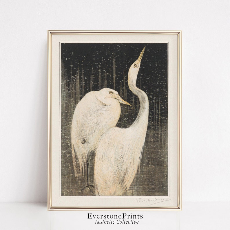 Op de afbeelding: Een vintage Japanse houtsnede met twee witte reigers die op een donkere, getextureerde achtergrond staan. De reigers staan ​​tegenover elkaar, met de nek van de ene reiger gebogen naar achteren. De print is onderaan rechts gesigneerd met "Hiroshi Yoshida".