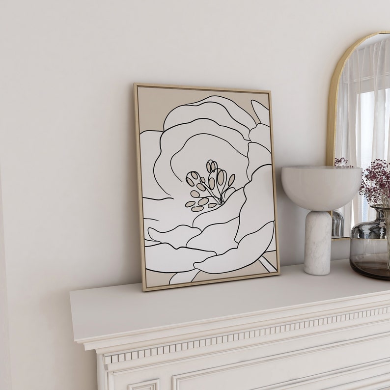 Pu&ograve; includere: Una stampa incorniciata di un disegno in bianco e nero di un fiore su sfondo beige.