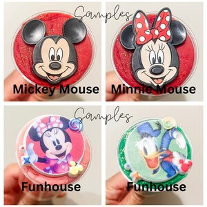 K&ouml;nnte beinhalten: Vier runde Beh&auml;lter mit verschiedenen Disney-Charakterdesigns. Die Beh&auml;lter sind mit rotem, rosa, gr&uuml;nem und rotem Schleim gef&uuml;llt. Die Beh&auml;lter sind mit "Mickey Mouse", "Minnie Mouse", "Funhouse" und "Funhouse" beschriftet.