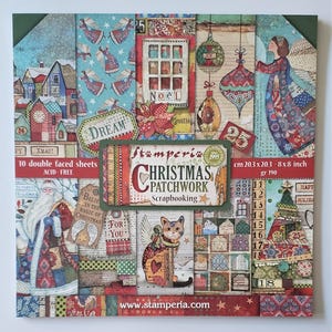 May include: A square stack of Christmas-themed scrapbook paper. The paper features various designs, including angels, ornaments, Santa Claus, and a cat. The text "Christmas Patchwork Scrapbooking" is visible, with measurements of 20.3 x 20.3 cm.