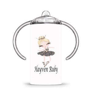 Op de afbeelding: Witte tuitbeker met een ballerina-illustratie. Het ontwerp toont een blonde ballerina in een zwarte tutu en een gouden kroon. De naam "Hayven Ruby" staat eronder gedrukt. De beker heeft doorzichtige handvatten en een doorzichtig deksel.