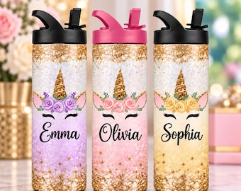 Könnte beinhalten: Drei zylindrische Wasserflaschen mit schwarzen oder pinken Klappdeckeln. Jede Flasche hat oben und unten Goldglitzer, ein Einhorn-Motiv mit Blumenakzenten und die Namen Emma, Olivia oder Sophia in schwarzer Schreibschrift.