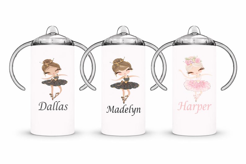 Op de afbeelding: Drie witte tuitbekers met zilveren handvatten en doppen, elk met een ballerina-illustratie. De eerste beker heeft de naam "Dallas", de tweede "Madelyn" en de derde "Harper". De ballerina's dragen tutu's en kronen.