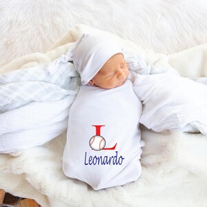 May include: White baby onesie with a red letter L and a baseball graphic. The onesie is personalized with the name Leonardo.