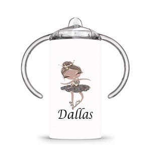 Op de afbeelding: Witte tuitbeker met een cartoon illustratie van een ballerina. De ballerina draagt een kroon en een grijze tutu. De naam "Dallas" is in zwart schrift eronder gedrukt. De beker heeft doorzichtige handvatten en een doorzichtige bovenkant.