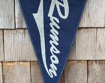 May include: A navy blue triangular pennant with white embroidered text that reads "Swimmers".
