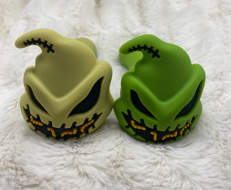 May include: Two silicone pipes shaped like the character Jack Skellington from the movie The Nightmare Before Christmas. One pipe is green and the other is a light green color.