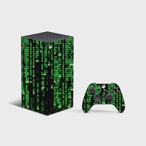 May include: A black gaming console and a matching wireless controller, both featuring a skin with a green digital code pattern. The console has a rectangular tower shape with a top vent, and the controller includes standard buttons and joysticks.