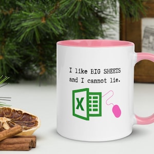 May include: White ceramic mug with a pink rim and handle. The mug has a green Excel logo and the text "I like BIG SHEETS and I cannot lie."