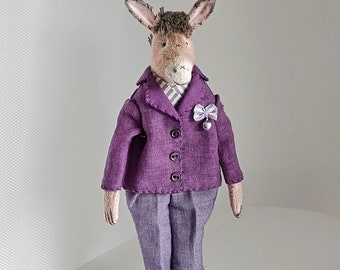 A donkey doll in a purple men's suit, a textile interior toy in vintage style on a stand.