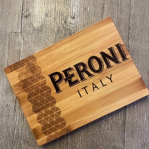 May include: A wooden cutting board with a geometric pattern and the text "PERONI ITALY" engraved on it.