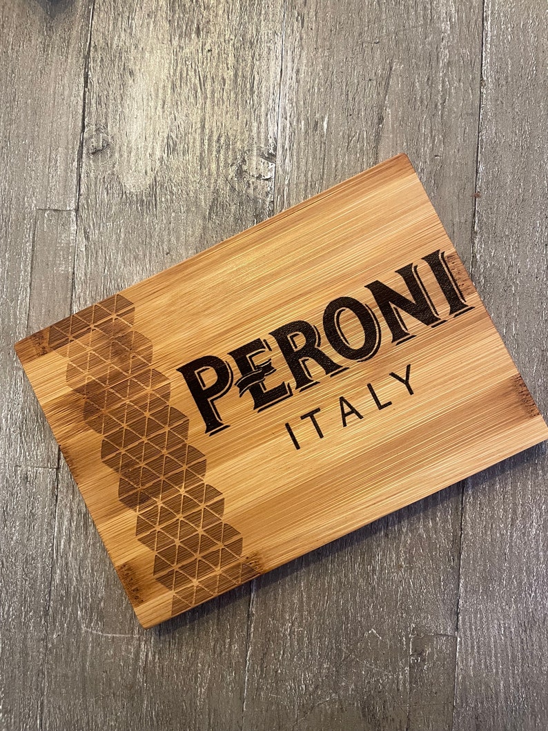 May include: A wooden cutting board with a geometric pattern and the text "PERONI ITALY" engraved on it.