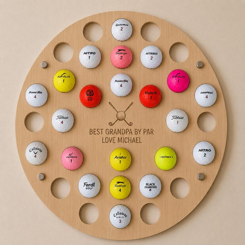 May include: A round wooden golf ball display board with holes holding various golf balls. The balls are different colors and brands. The text "BEST GRANDPA BY PAR LOVE MICHAEL" is in the center.