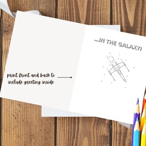 May include: A blank card with a black and white illustration of a spaceship flying through space. The text on the card reads "...IN THE GALAXY!"