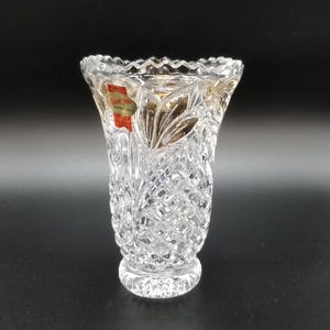 May include: A clear glass vase with a cut crystal design. The vase has a label that reads "Anna-Jones Bohemia Crystal".