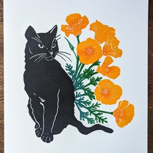May include: A print featuring a black cat silhouette alongside orange California poppies and green leaves. The cat is depicted sitting and gazing left. The flowers are in full bloom, with detailed petals.