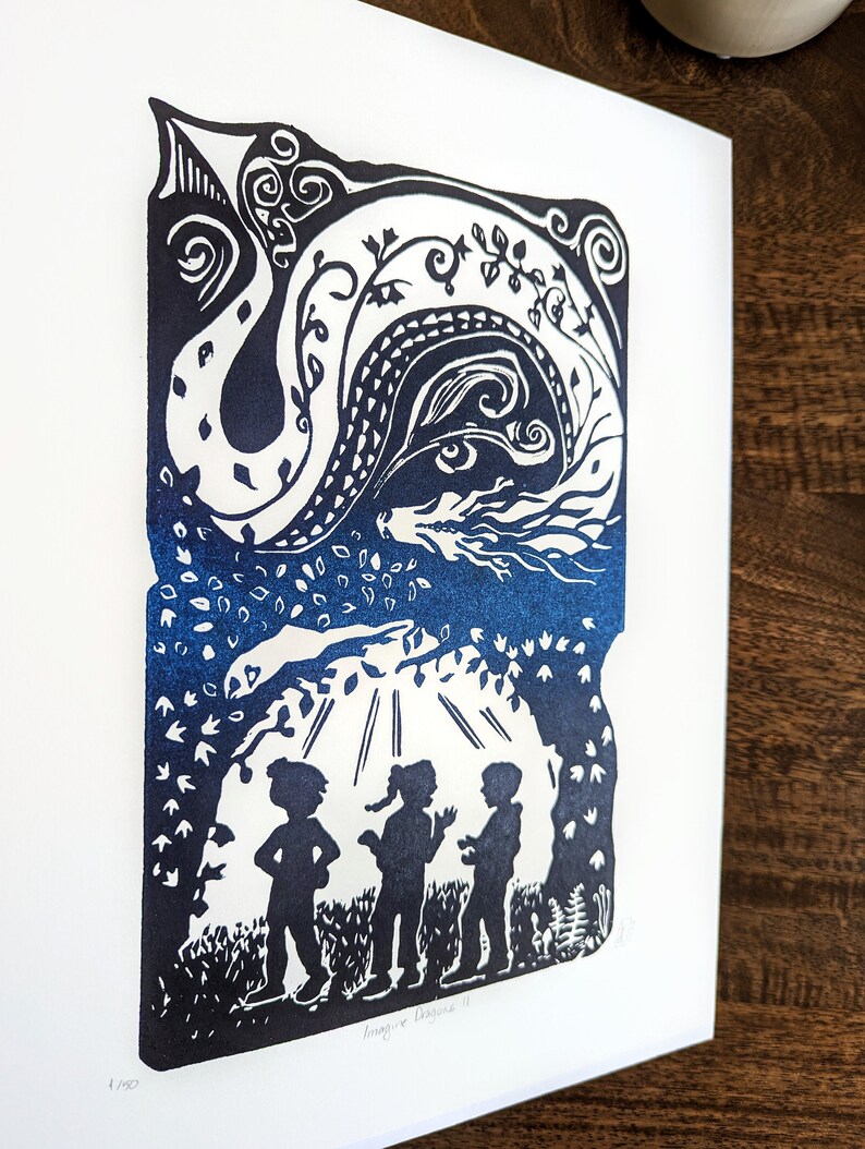 May include: A blue and white linocut print of three children standing in a forest with a dragon in the sky above them. The print is titled "Imagine Beyond".