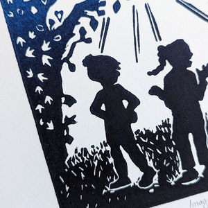May include: A blue and white linocut print of two figures standing in a forest. The figures are silhouetted against a white background with a tree and sun rays above them. The print is numbered 1/150.
