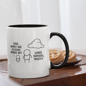 Könnte beinhalten: Weißer Kaffeebecher mit schwarzem Innenraum und Henkel. Der Becher hat eine humorvolle Grafik mit dem Text "Papa, woraus bestehen Wolken?" und "Linux-Server, meistens". Eine Wolke und Strichmännchen sind ebenfalls enthalten.