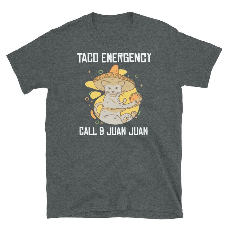 Pode incluir: Uma camiseta cinza escura mesclada com um gr&aacute;fico branco de um gato usando um sombrero e segurando um taco. O texto "Taco Emergency" est&aacute; acima do gato e "Call 9 Juan Juan" est&aacute; abaixo do gato.