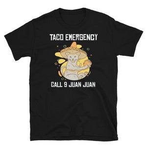 Pode incluir: Camiseta preta com um gr&aacute;fico branco de um gato usando um sombrero e segurando um taco. O texto "Taco Emergency" e "Call 9 Juan Juan" est&aacute; impresso na camiseta.
