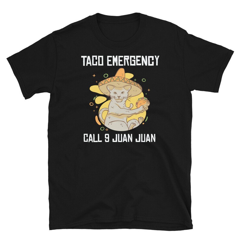 Pode incluir: Camiseta preta com um gr&aacute;fico branco de um gato usando um sombrero e segurando um taco. O texto "Taco Emergency" e "Call 9 Juan Juan" est&aacute; impresso na camiseta.