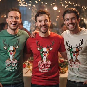 以下が含まれることがあります： トナカイのデザインのTシャツを着た3人。トナカイはアイルランドの国旗の色と赤い鼻をしています。「Tiocfaidh Ar Lá La la la la」というテキストが下にあります。シャツは緑、赤、白です。