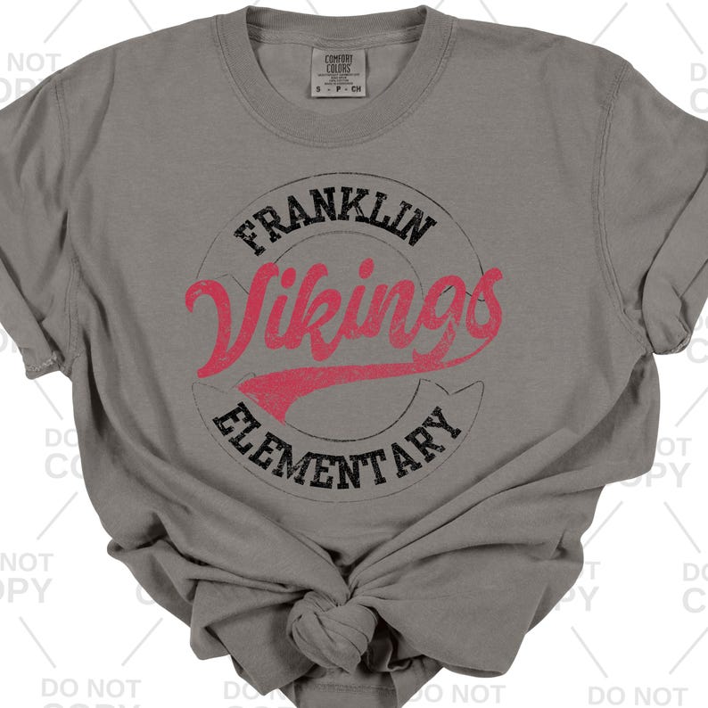 May include: A gray Comfort Colors t-shirt featuring a distressed graphic. The graphic includes the words "FRANKLIN Vikings ELEMENTARY" in a circular design with red and black lettering.