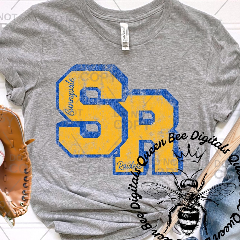 May include: A heather gray t-shirt featuring the letters "SR" in yellow and blue, with "Sunnyvale" and "Raiders" text. The shirt also has a graphic of a bee and the text "Queen Bee Digitals".