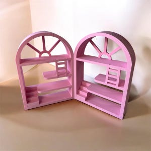 May include: Two pink, arched-window-shaped shelves. Each shelf has a sunburst design at the top, multiple shelves, and either a staircase or a ladder. The shelves are made of wood and painted a solid pink colour.