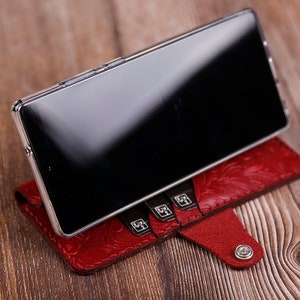 Estuche de cuero tipo billetera con carga inalámbrica para Samsung Galaxy S25 Edge, S25+, S24 FE y S23 FE. Cuero de grano completo repujado. Cuero genuino color cereza.