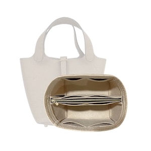 Pode incluir: Organizador de bolsa de feltro bege com vários compartimentos e um bolso com zíper. O organizador é projetado para caber dentro de uma bolsa tote maior.