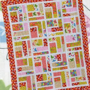 May include: A colorful patchwork quilt with a red floral border and white sashing. The quilt features a variety of patterned fabrics in pink, yellow, green, and red, with butterfly and floral designs. Text reads "Bundle of 10" and "10 fat quarters & 2 contrast yards."
