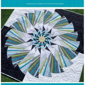 May include: A quilt pattern called "Twirl" by Amanda Murphy Design. The quilt features a swirling design in shades of blue, green, white, and black.