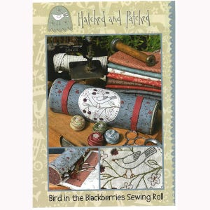 May include: A sewing roll with a bird and floral design, red straps, and the text "Bird in the Blackberries Sewing Roll." The image also shows spools of thread, fabric, and a sewing machine.