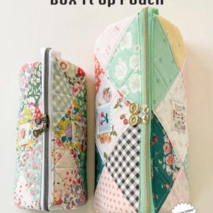 May include: Two patchwork fabric pouches with zipper closures. The pouches are in a variety of floral and geometric patterns, with a mint green zipper and accents. The text "Box It Up Pouch" is at the top, with "MINKI KIM" and a website address at the bottom.