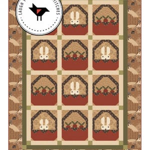 May include: A quilt pattern called "Carrot Patch" featuring a grid of 12 squares with a brown, white, and green color scheme. Each square features a white bunny in a brown house with a red carrot patch. The quilt is 60 inches by 82 inches.