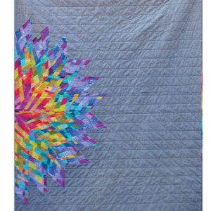 May include: A quilted textile featuring a vibrant, colorful floral design on a gray background. The quilt, titled "Luminary," is 42" x 55" and has a geometric pattern. The design includes the text "alison glass" and "BY JAMIE SWANSON".