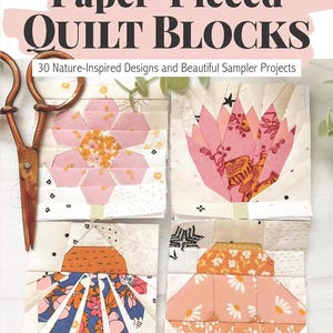 May include: A book cover titled "Wonderful World of Paper-Pieced Quilt Blocks" with four colorful quilt block designs. The book features 30 nature-inspired designs and sampler projects. A pair of vintage scissors is on the left.
