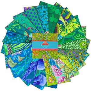 May include: A collection of fabric squares in various shades of green and blue, arranged in a circular pattern. The fabrics feature diverse patterns, including polka dots, floral designs, and abstract shapes. A teal band with text is in the center.