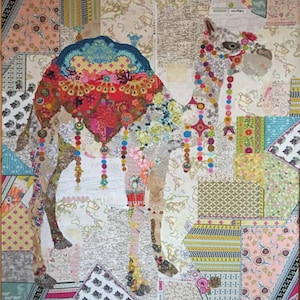 May include: A colorful camel collage titled "Caleb" by Laura Heine. The artwork features a patchwork design with various patterned fabrics in shades of pink, blue, green, and yellow. The camel is adorned with decorative elements and hanging beads. The text "CALEB...CAMEL COLLAGE BY LAURA HEINE" is at the top.