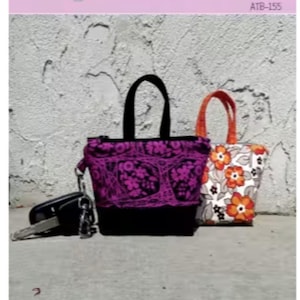 May include: Two small tote bags, one with a purple floral design and the other with orange flowers on a white background. The bags are approximately 4 inches high, 4.5 inches wide, and 1.5 inches deep. The text "Itty Bitty Totes" is visible.