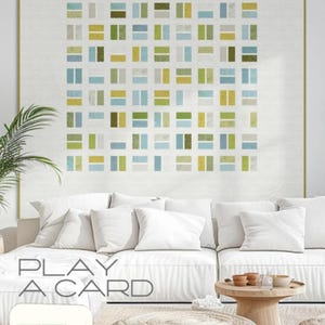 May include: A large framed artwork featuring a geometric pattern of rectangular shapes in shades of green, blue, and yellow on a white background. The artwork hangs above a white sofa. The text "PLAY A CARD" and "ZEN CHIC" are also visible.