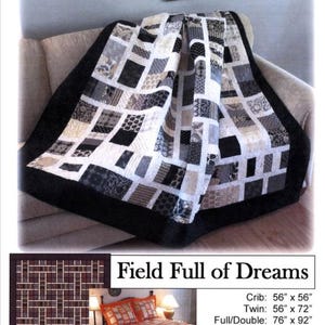 May include: A patchwork quilt with a black border, featuring squares in shades of gray, white, and black. The quilt is draped over a beige sofa. The text "Field Full of Dreams" is visible, along with size details for crib, twin, full/double, queen, and king sizes.