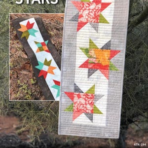 May include: A quilted table runner with a star pattern in red, green, gray, and white. The text "Desert STARS" is at the top. The design features a repeating star motif, with a smaller version of the runner in the background.